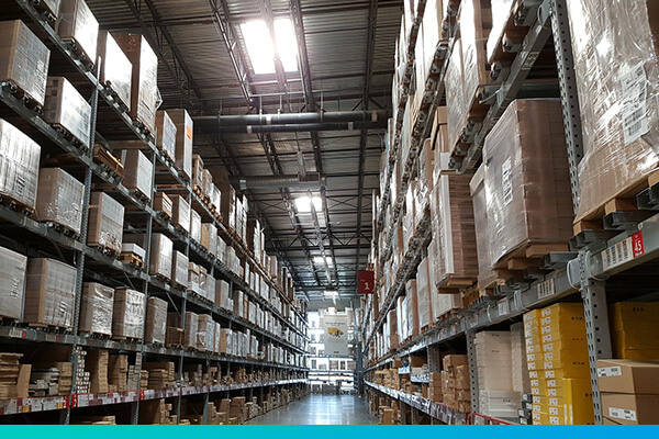 Auf Paletten in Regalen gelagerte Warenkartons in einer Lagerhalle