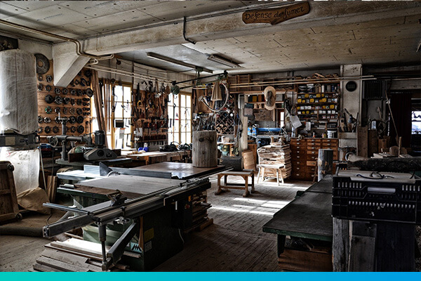 Innenansicht einer Werkstatt mit Arbeitsplatten und Werkzeugen an der Wand